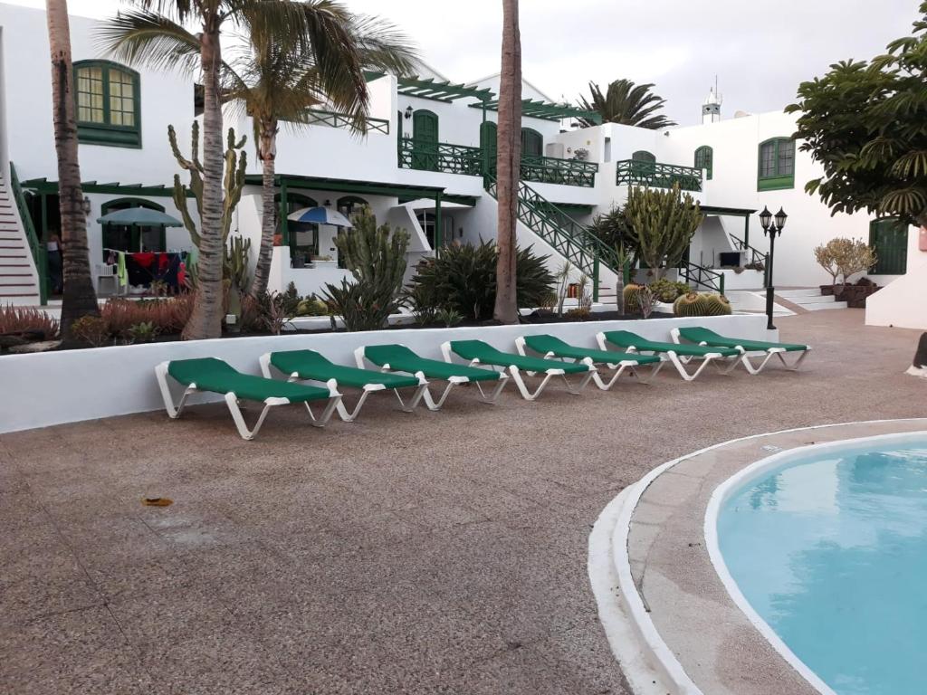 蒂亚斯Casa Dany的游泳池旁的一排绿色躺椅