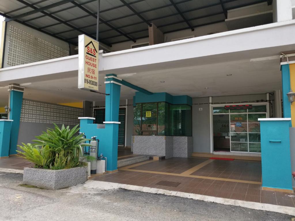 关丹S & S Guest House Kuantan的商店前有蓝色柱子的建筑物