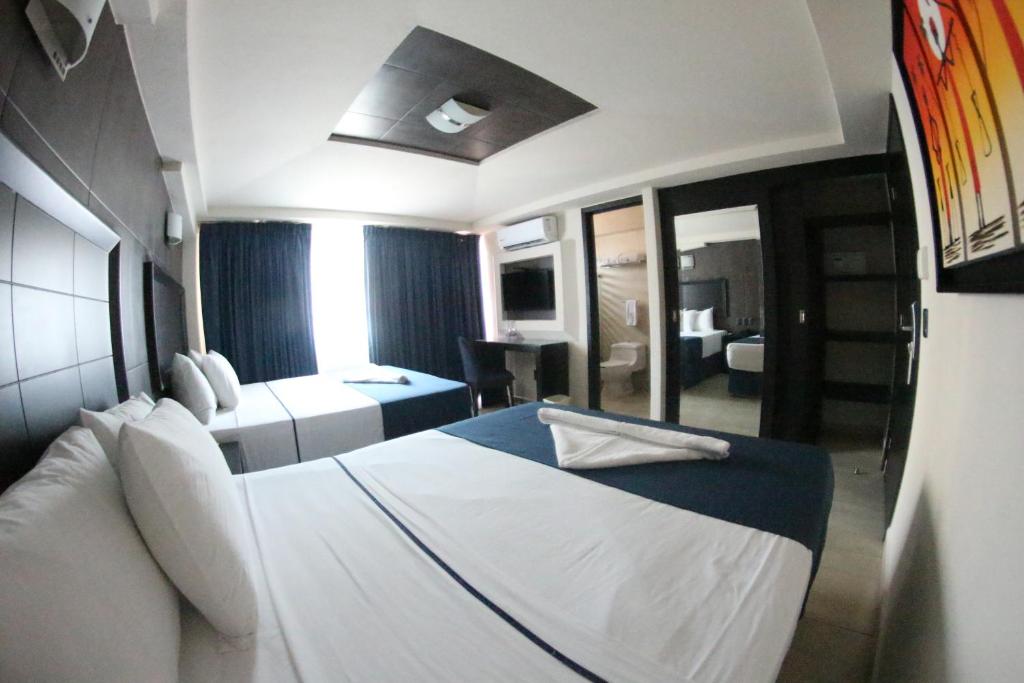 巴亚尔塔港马勒孔波多诺伏广场酒店的酒店客房设有一张白色大床和一间卧室。