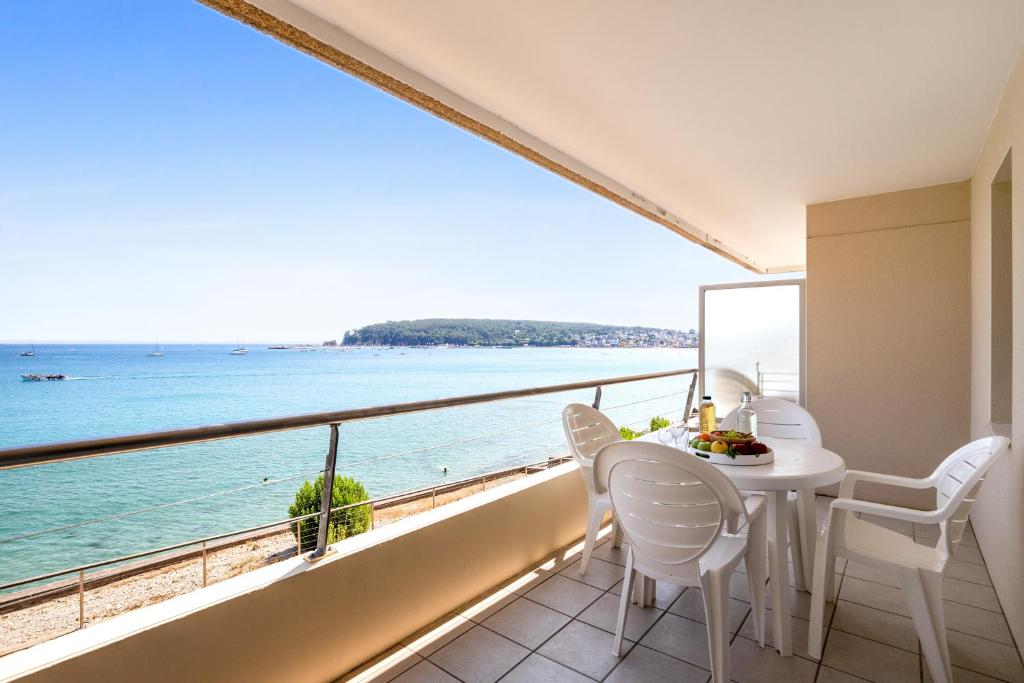 克罗宗Résidence Pierre & Vacances Cap-Morgat的阳台配有桌椅,享有海景。