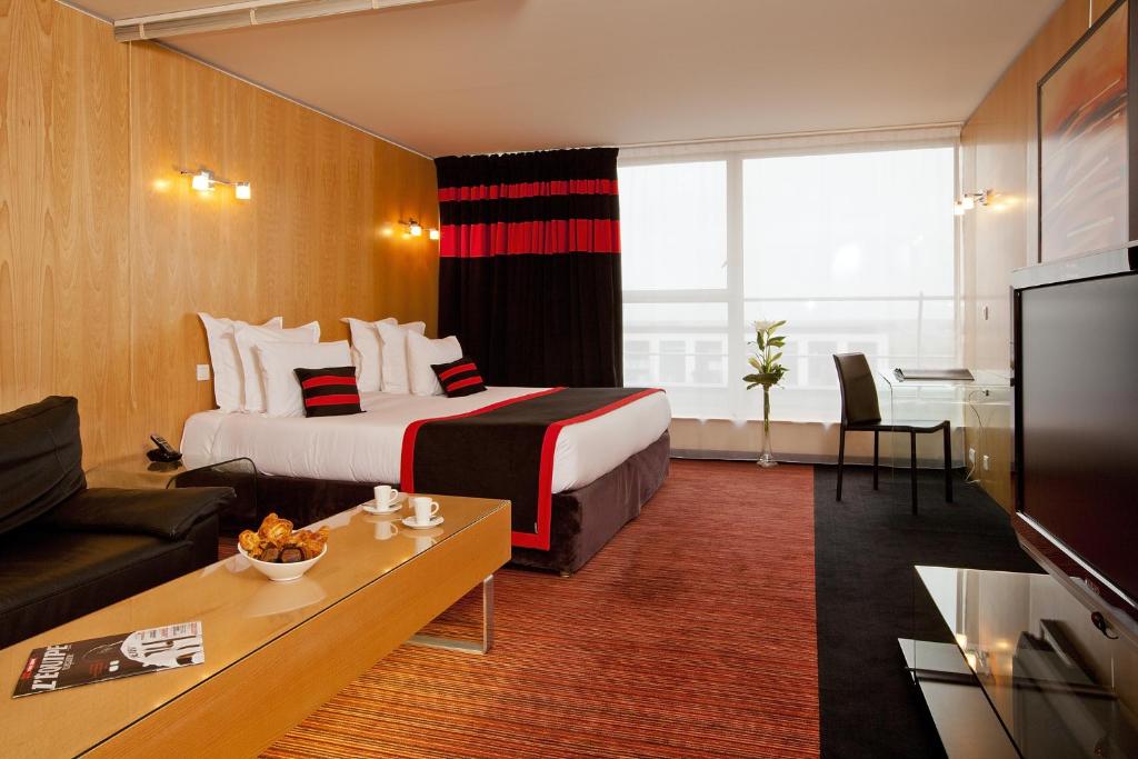 略桑巴黎苏德森特号角套房酒店的酒店客房,配有床和沙发