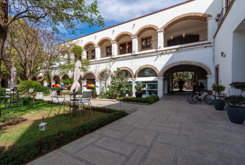 莱昂Hotel Hacienda San Cristóbal的一座带桌椅的建筑的庭院