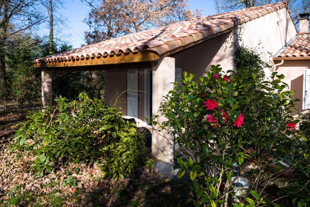 FontenillesGîte Les chênes的一座带瓷砖屋顶和一些鲜花的房子
