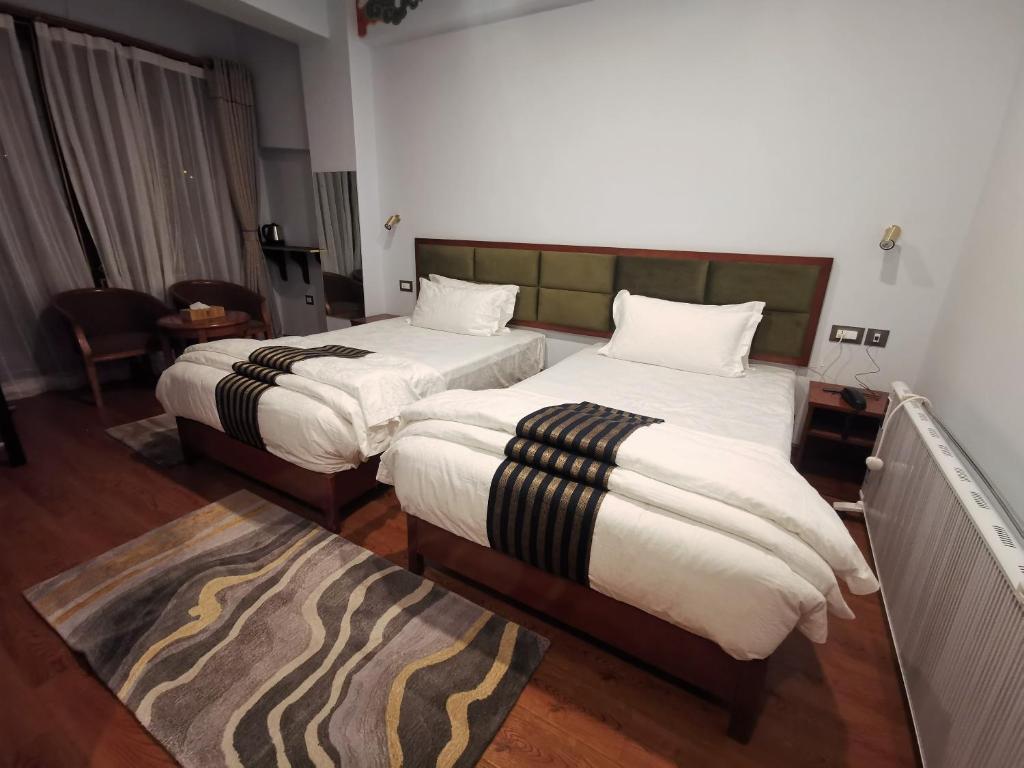 廷布Ludrong Hotel的酒店客房带两张床和地毯