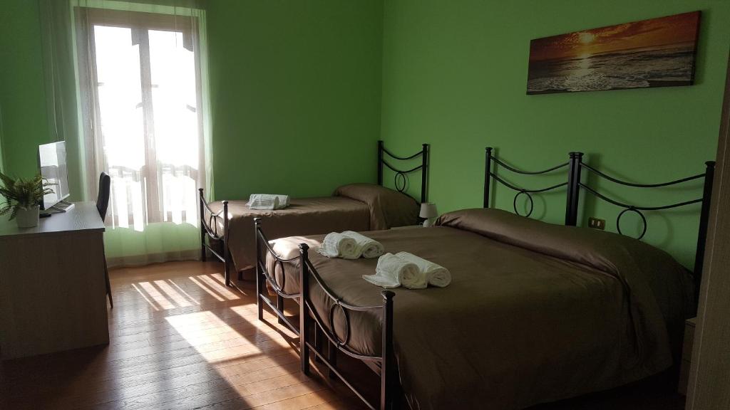 菲乌米奇诺Pisicchio Rooms的绿墙客房内的两张床