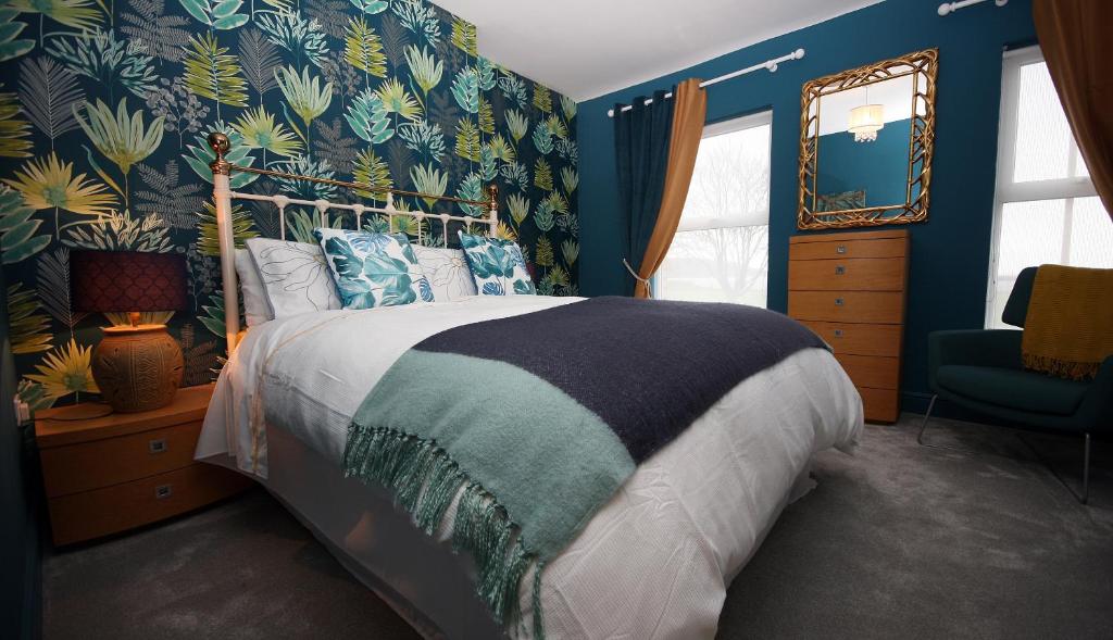 班戈Moryn. Snowdonia and Anglesey View的一间卧室配有一张带蓝色墙壁的大床