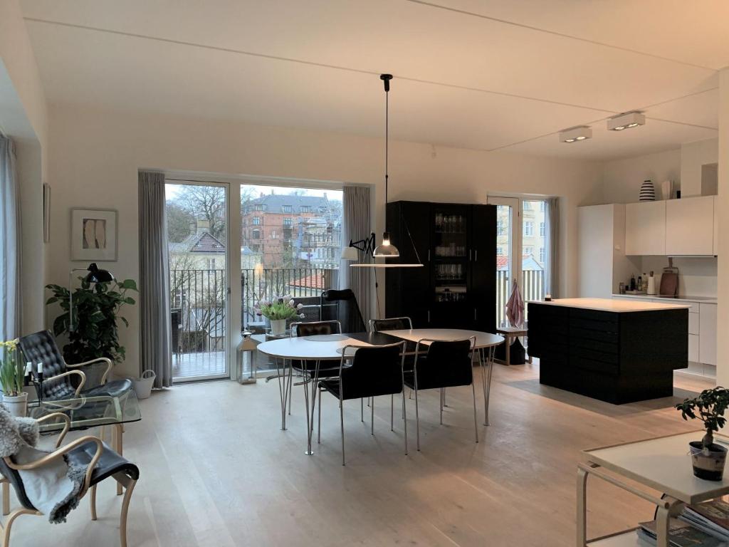 哥本哈根ApartmentInCopenhagen Apartment 1440的一间厨房和带桌椅的客厅