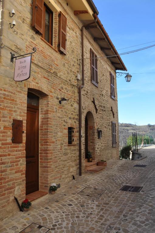 MontefortinoB&B Terra di Marca的砖砌的建筑,旁边标有标志