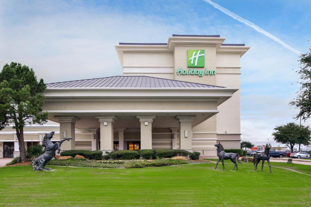 理查森Holiday Inn Dallas-Richardson, an IHG Hotel的建筑前有两座雕像的酒店