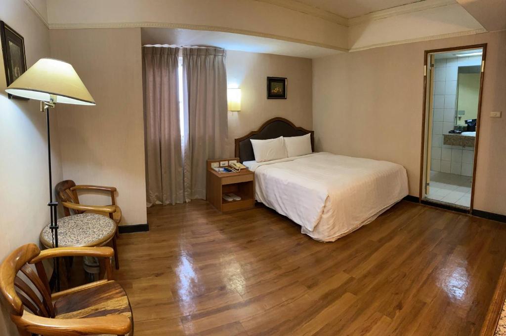 东港大鹏湾度假酒店的卧室配有1张床、1张桌子和1把椅子