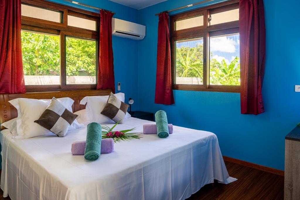 波拉波拉Kovailani 1232 DTO-MT的一间卧室设有两张带蓝色墙壁和窗户的床。