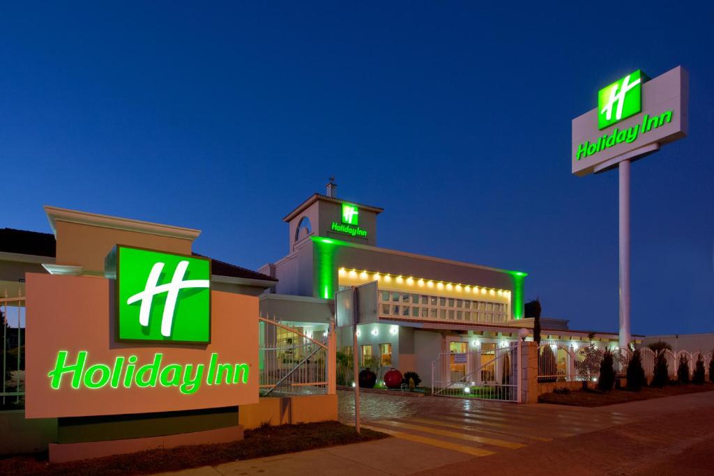 杜兰戈杜兰戈假日酒店的一座建筑上带有绿色 ⁇ 虹灯标志的医院