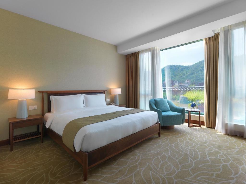 台北有诚商旅的酒店的客房 - 带一张床、椅子和窗户