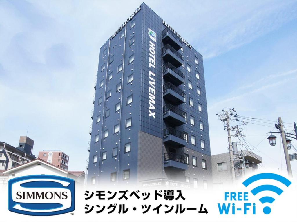 相模原市HOTEL LiVEMAX Minamihashimoto Ekimae的一座高大的蓝色建筑,上面有文字西蒙人家