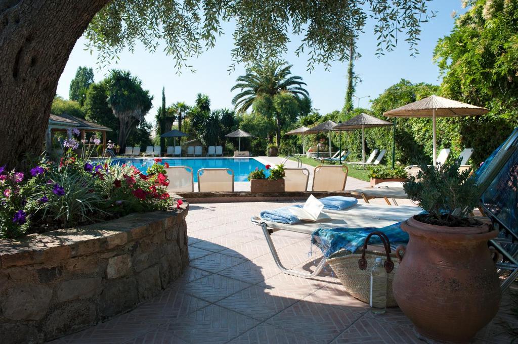 古维亚Spiti Prifti Apartments的一个带桌椅的庭院和一个游泳池