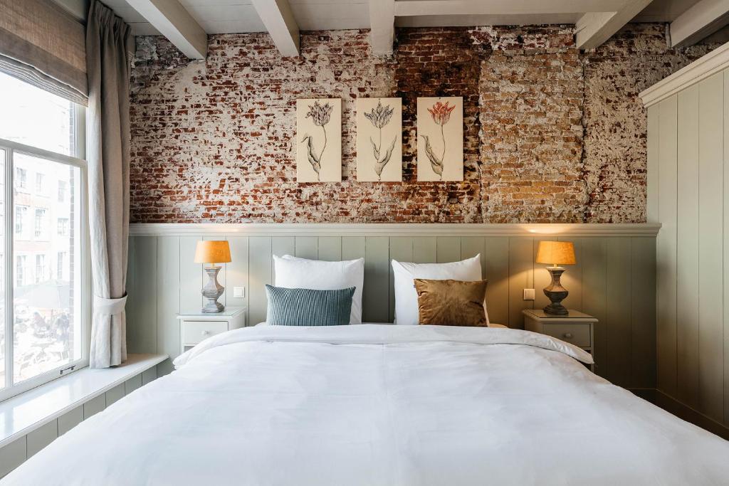 乌得勒支Logement Petit Beijers的卧室配有白色的床和砖墙