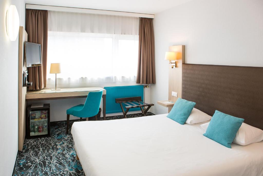 里尔欧洲里尔酒店的配有一张床和一张书桌的酒店客房
