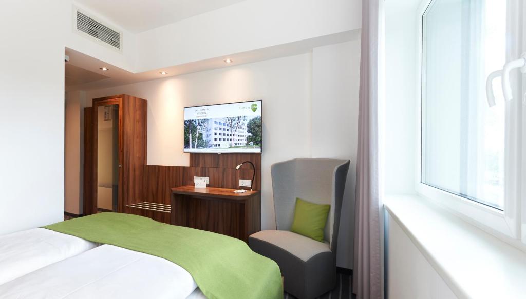 纽伦堡第一酒店的卧室配有床、椅子和窗户。