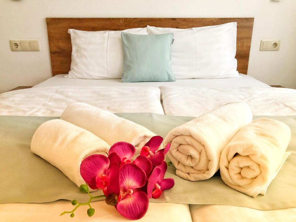 蒂萨菲赖德Boró Apartman的床上有毛巾和鲜花
