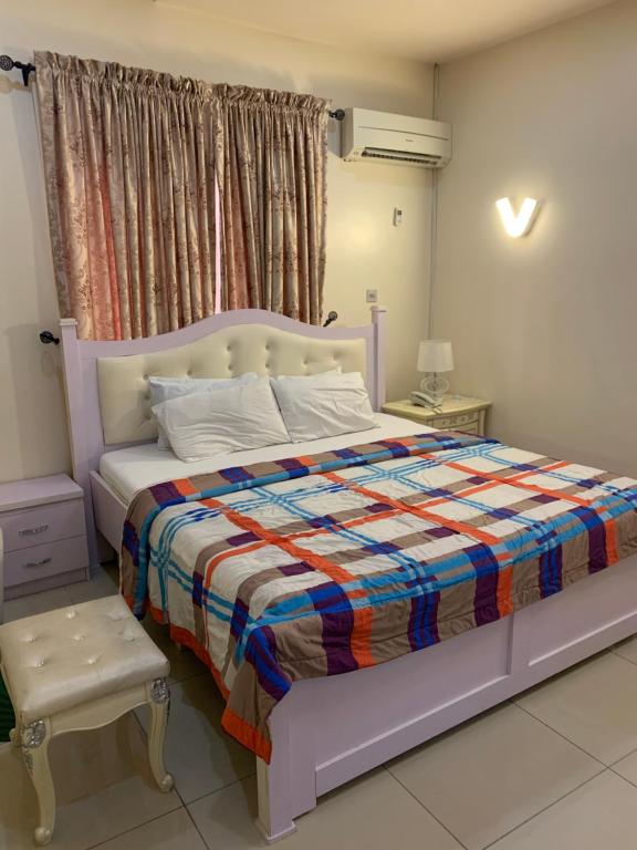 拉各斯Greens Manor VI的一间卧室配有一张大床和色彩缤纷的毯子
