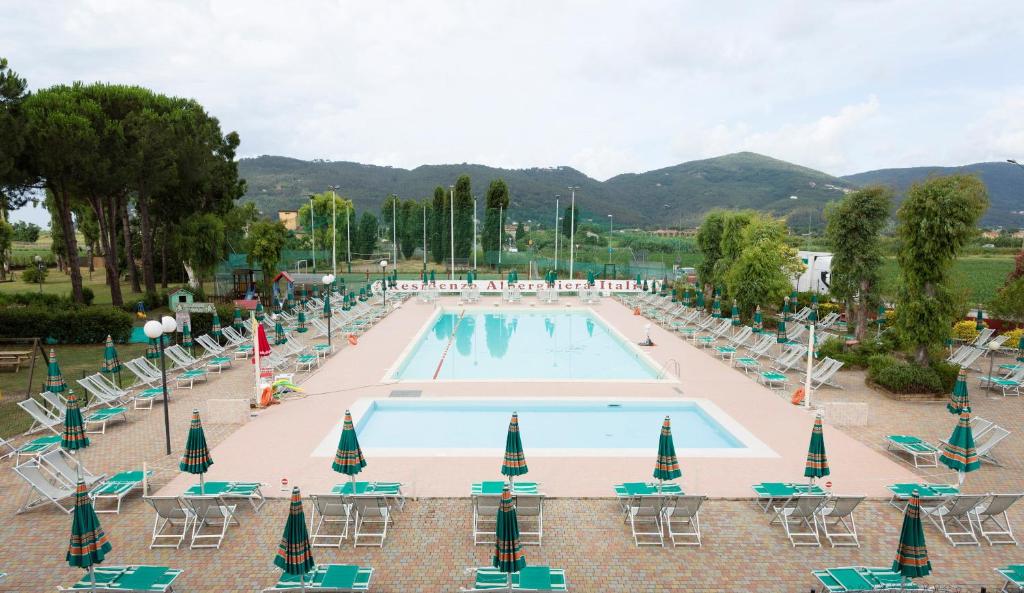 Luni艾伯塔盖拉意大利住宅酒店的一个带躺椅和桌子的大型游泳池