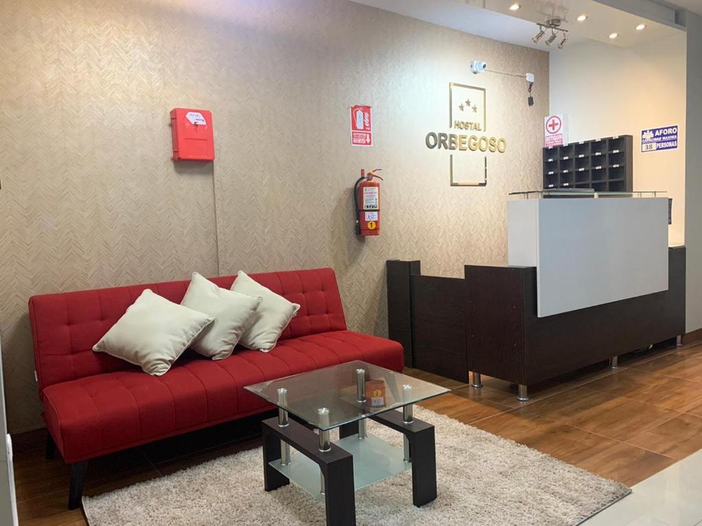 特鲁希略ORBEGOSO - Trujillo的客厅配有红色的沙发和桌子