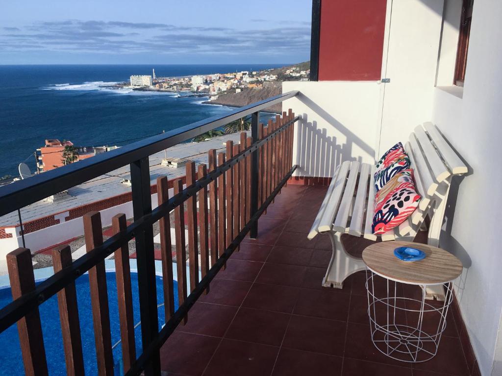 巴哈马尔Sunset Dream Bajamar GREAT VIEWS的阳台设有长凳和桌子,享有海景。