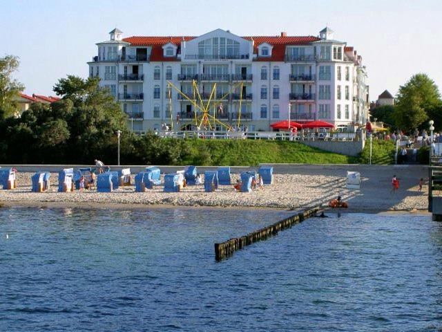 奥斯赛拜-屈隆斯博恩Apartmenthaus Atlantik的海滩上摆放着椅子,建筑背景