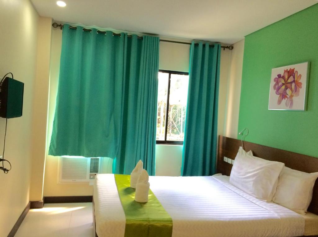 塔比拉兰Cresebo Mansion的一间卧室设有一张带绿色墙壁和窗户的床。