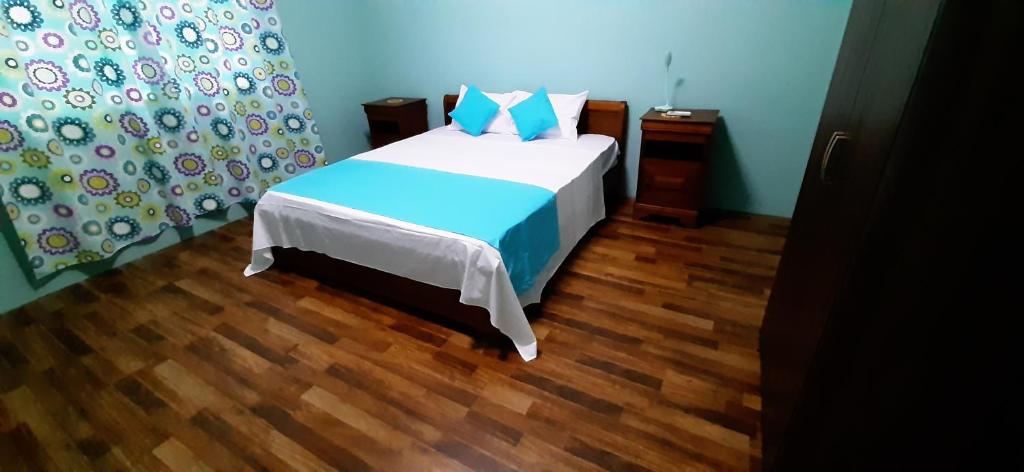 路易港Casa Accacias的一间卧室配有一张床,铺有木地板