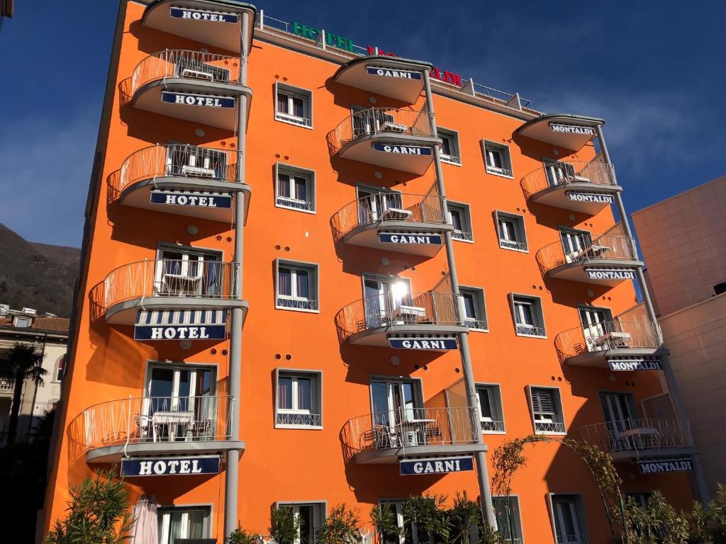 洛迦诺加尼蒙塔尔迪酒店的一座橙色的建筑,旁边设有阳台