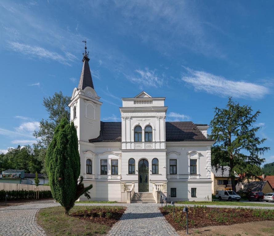 罗斯诺夫·波德·拉德霍斯滕Villa Rosenaw的一座白色的大建筑,上面有陡峭的陡峭