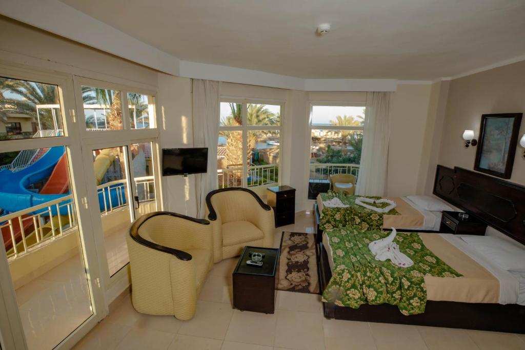 赫尔格达沙滩度假酒店的配有一张床和一把椅子的酒店客房