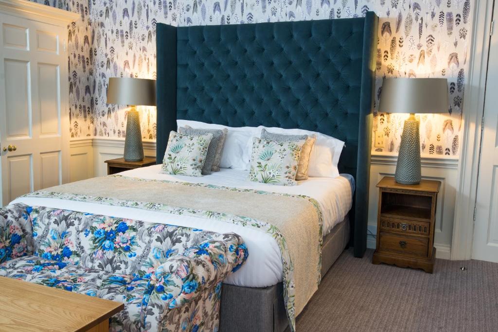 约克法官旅舍 的一间卧室配有一张大床和蓝色床头板