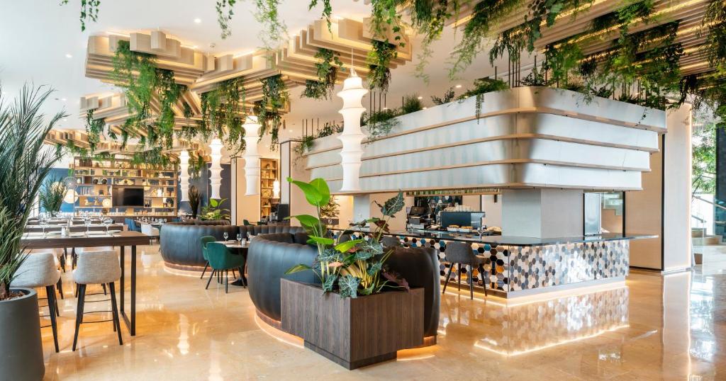 瓦伦西亚伊鲁尼瓦伦西亚4号康福特尔酒店的餐厅拥有植物天花板和桌子
