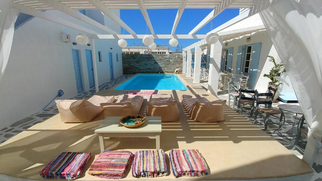 纳乌萨Hotel Marinero的庭院设有游泳池、桌子和椅子。