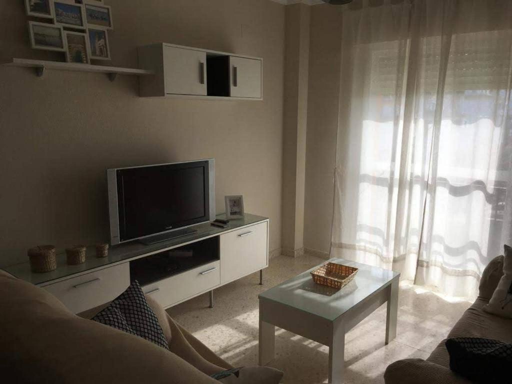 桑卢卡尔-德巴拉梅达Apartamento Acogedor的一间带电视和沙发的客厅