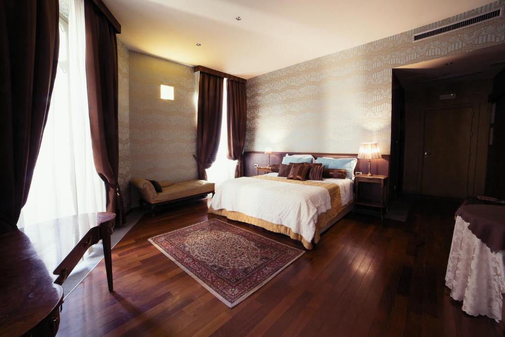 都灵德伊皮托利酒店的一间卧室配有一张床、一张沙发和一个窗口