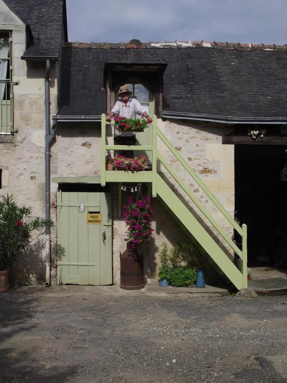 CheilléChambre d'hôtes Le Vaujoint的站在窗户上,拿着花盒的人
