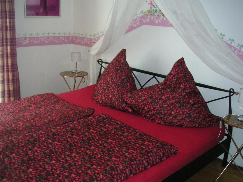 波滕施泰因霍夫蒂姆自然之源农家乐的红色的床,配有红色床单和枕头