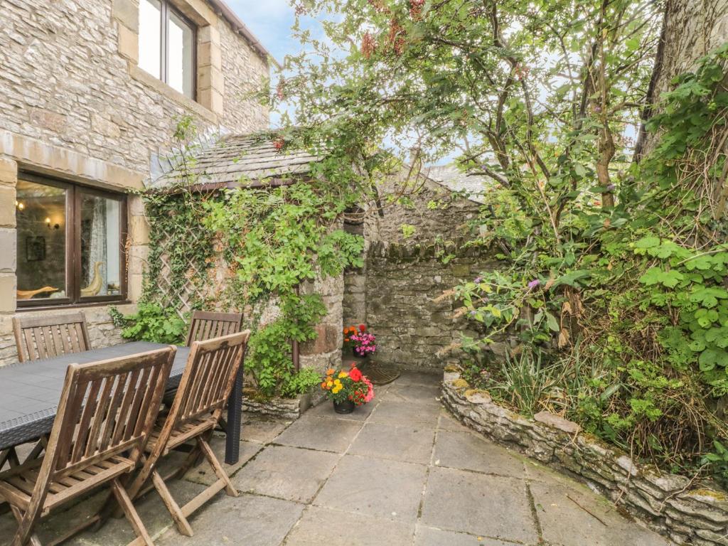MorlandSpringarth Cottage的庭院设有2张长椅和鲜花桌。