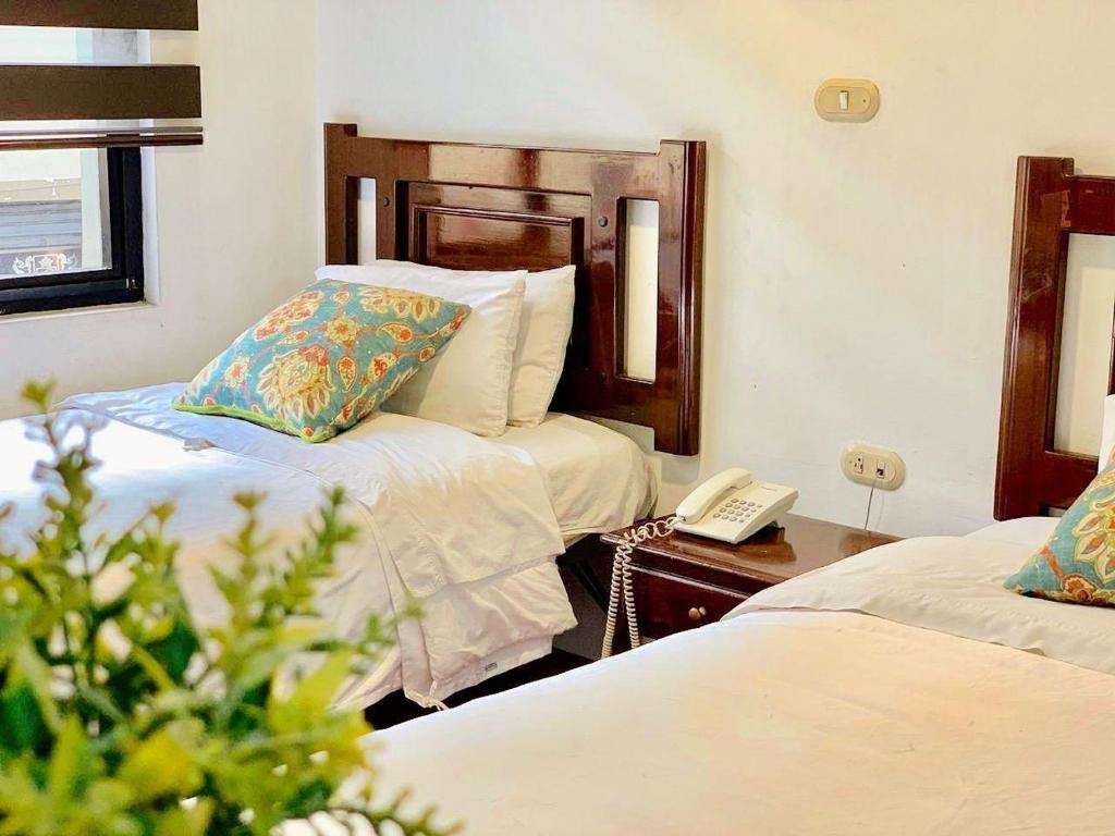昆卡HOSTAL EL CAJAS的酒店客房带两张床和电话