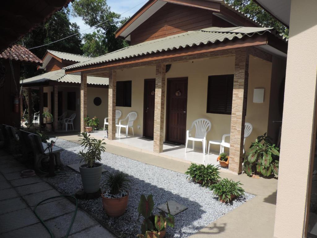 蜜岛Recanto Abayomi的庭院里种有椅子和植物的房子
