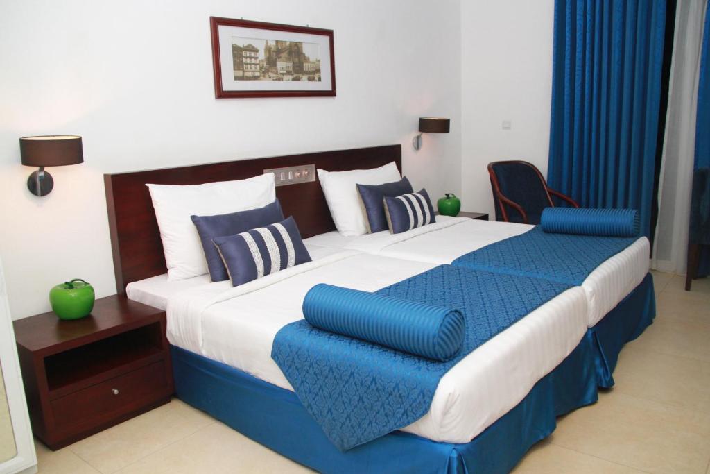 帕西库达Earl's Red Passikudah的一间卧室配有一张带蓝白色枕头的大床