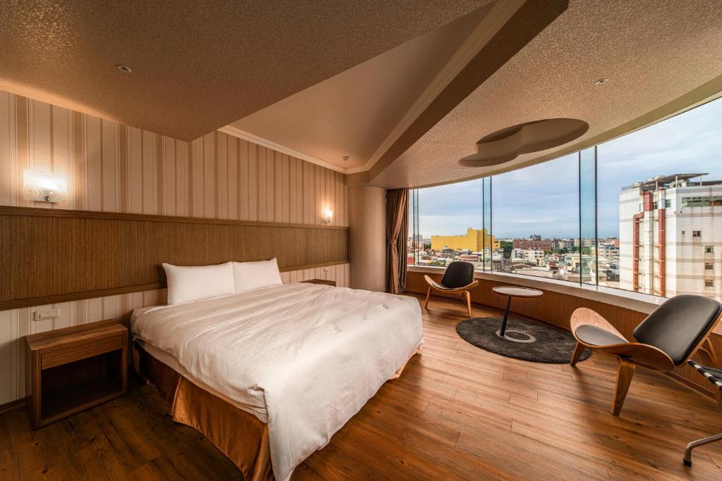 屏东县鮪魚家族飯店-屏東館的酒店客房设有一张床和一个大窗户