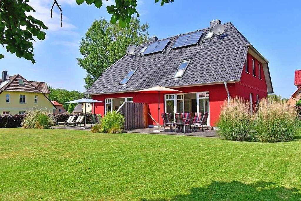 欧巴德伍斯图Haus STRANDHAFER WF-06 (links)的屋顶上设有太阳能电池板的红色房子