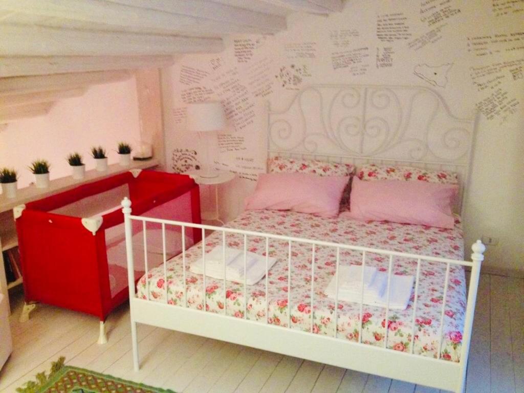 恩纳La Casa Sulla roccia的卧室配有白色的床和写字墙