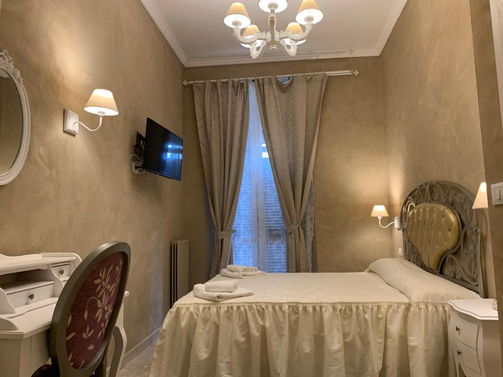 米兰Boutique Hotel Calais Milano的一间卧室配有一张带镜子的床和窗户