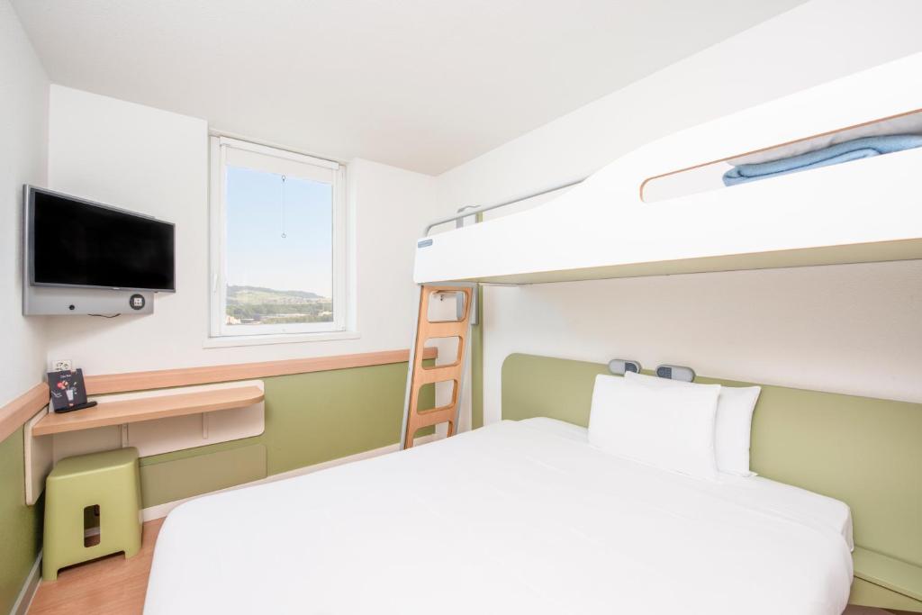 伯尔尼伯尔尼博览会宜必思快捷酒店的一间卧室配有双层床和电视