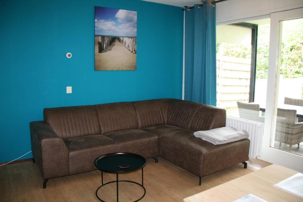 尼乌弗利特Schorrebloem 10的客厅设有棕色沙发和蓝色的墙壁。